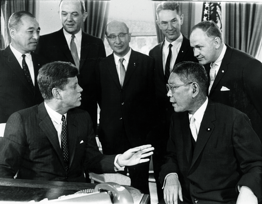 １９６１年６月２１日　ワシントン発　ホワイトハウスで２０日、一連の会談を前に、写真撮影に先立っておしゃべりするケネディ大統領（左）と池田勇人首相。後方左から朝海浩一郎・駐米大使、ディーン・ラスク国務長官、小坂善太郎外相、エドウィン・ライシャワー駐日米大使、通訳のジェームズ・ウィックル（ＵＰＩ＝共同）